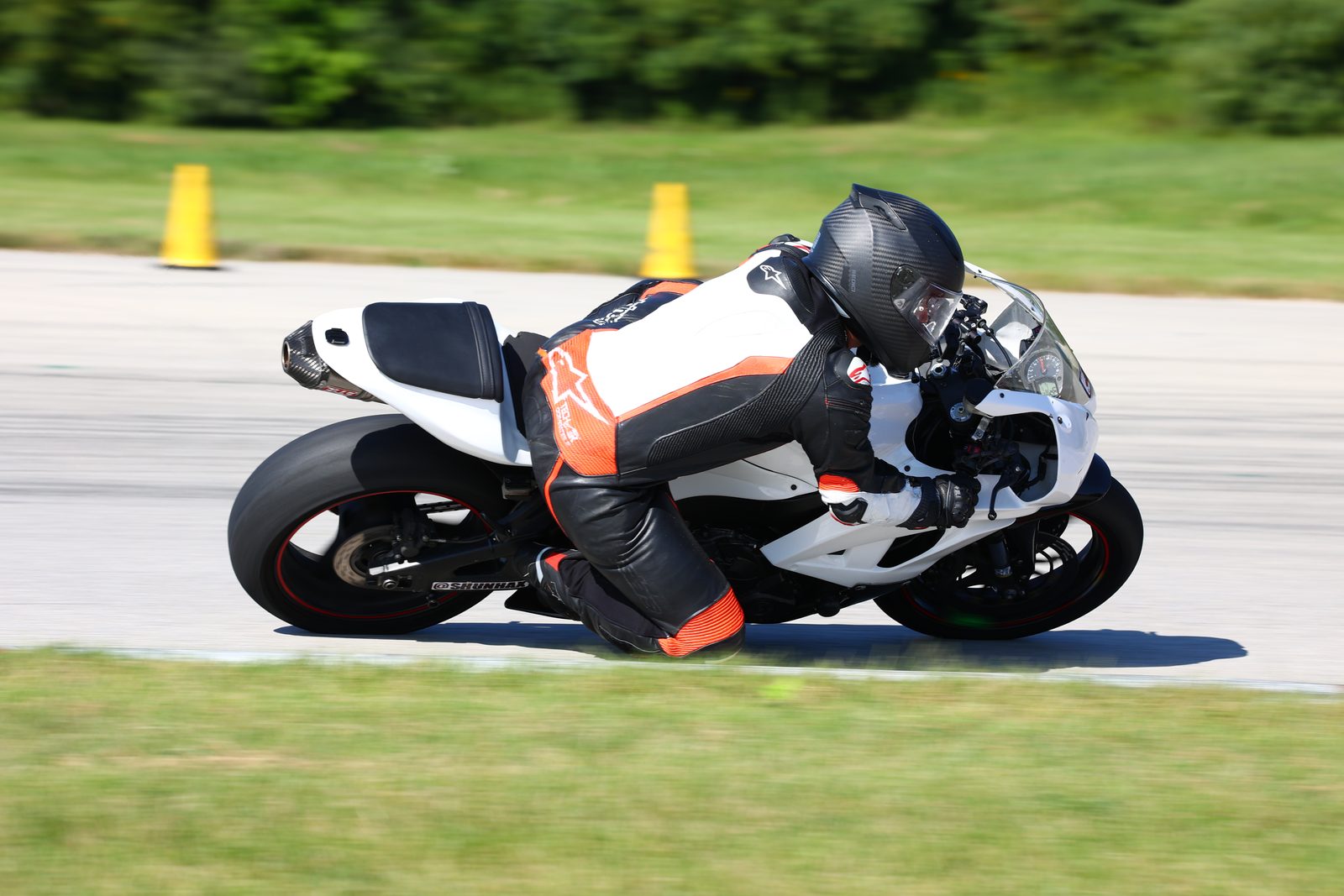 Chuck at full lean with his knee down on the white race bike at Autobahn North.